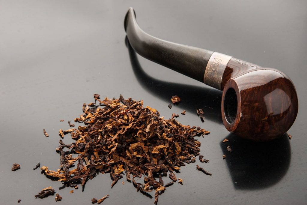 Pipe with tobacco on the dark table